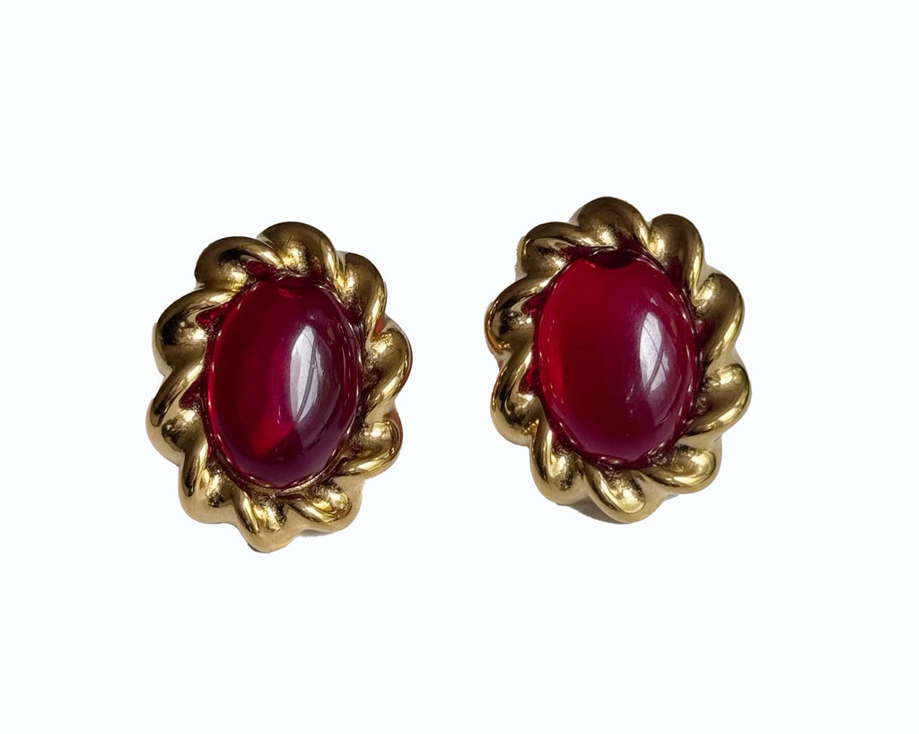 Vintage-style earrings featuring deep ruby-red oval stones, framed by sculpted gold-tone scalloped settings; a dramatic, passionate design that channels timeless romance and the emotional intensity of the Hopeless Romantic Society universe
